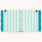 A three-ring binder with a striped cover in shades of mint green, teal, and white, featuring solid teal polka-dot side tabs and small dark gray decorative end tabs with gold hearts.