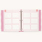 A pink and white ring binder planner insert set with nine blank lined boxes and decorative striped and polka-dot borders, shown open on a light background.