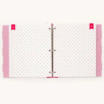 A white ring binder notebook with a delicate pink dotted pattern on the pages, featuring pink ribbon covers on the left and right sides and a silver metal ring closure in the center.