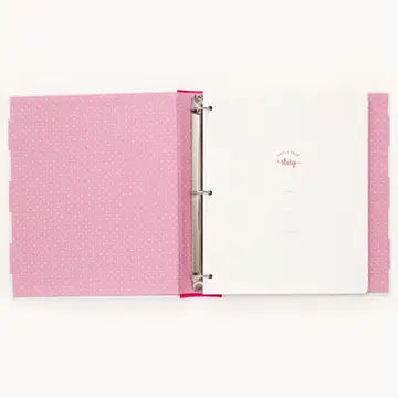 A pink ring binder notebook with a textured patterned cover, open to a white page with the word 'Baby' written in pink script.