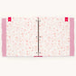 A three-ring binder notebook or planner cover featuring a delicate pink floral and heart pattern on a white background, with pink polka-dotted side tabs and red ribbon ties.