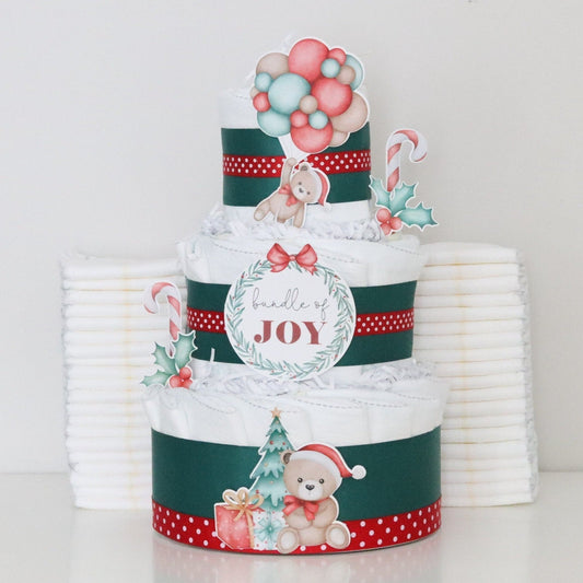 three-tiered diaper cake with Christmas-themed decorations on a white background